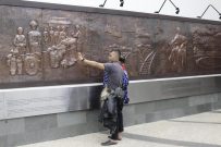 Pengunjung berfoto di relief Taman Sejarah, Jalan Wastukencana, Bandung. Selasa,(28/3/2017). (Septian Setiawan/Magang)